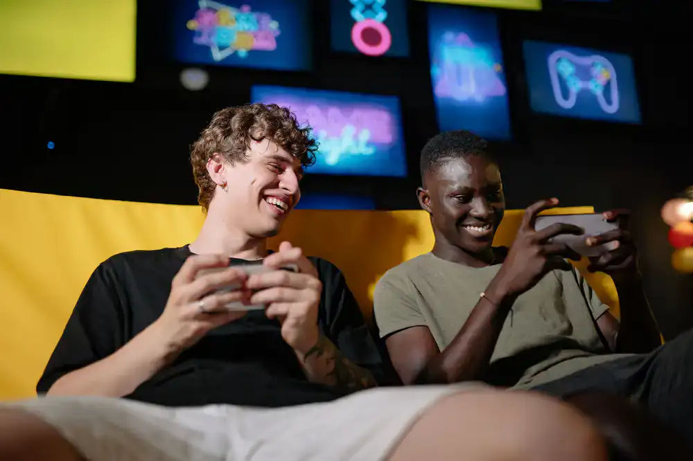Bright studio space with team members playing games on mobile devices